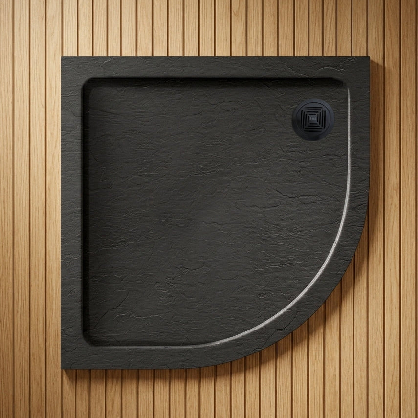 Black semi-circular shower tray on a wooden floor